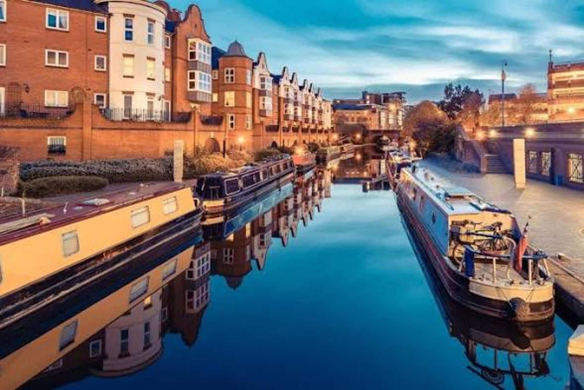 A canal with boats docked on both sides, surrounded by buildings with traditional architecture.