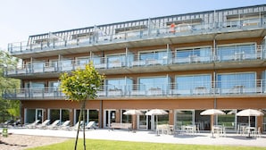 Un hôtel à plusieurs étages doté de balcons, d’un espace extérieur aménagé et d’une piscine.