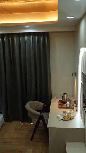 A modern room with a dining area, a chair, a table with food and drinks, and a curtain. - The Heaven Paradise Premium (Shimla)