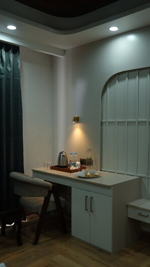 A compact kitchen with a dining area, a coffee maker, and a small cabinet. - The Heaven Paradise Premium (Shimla)