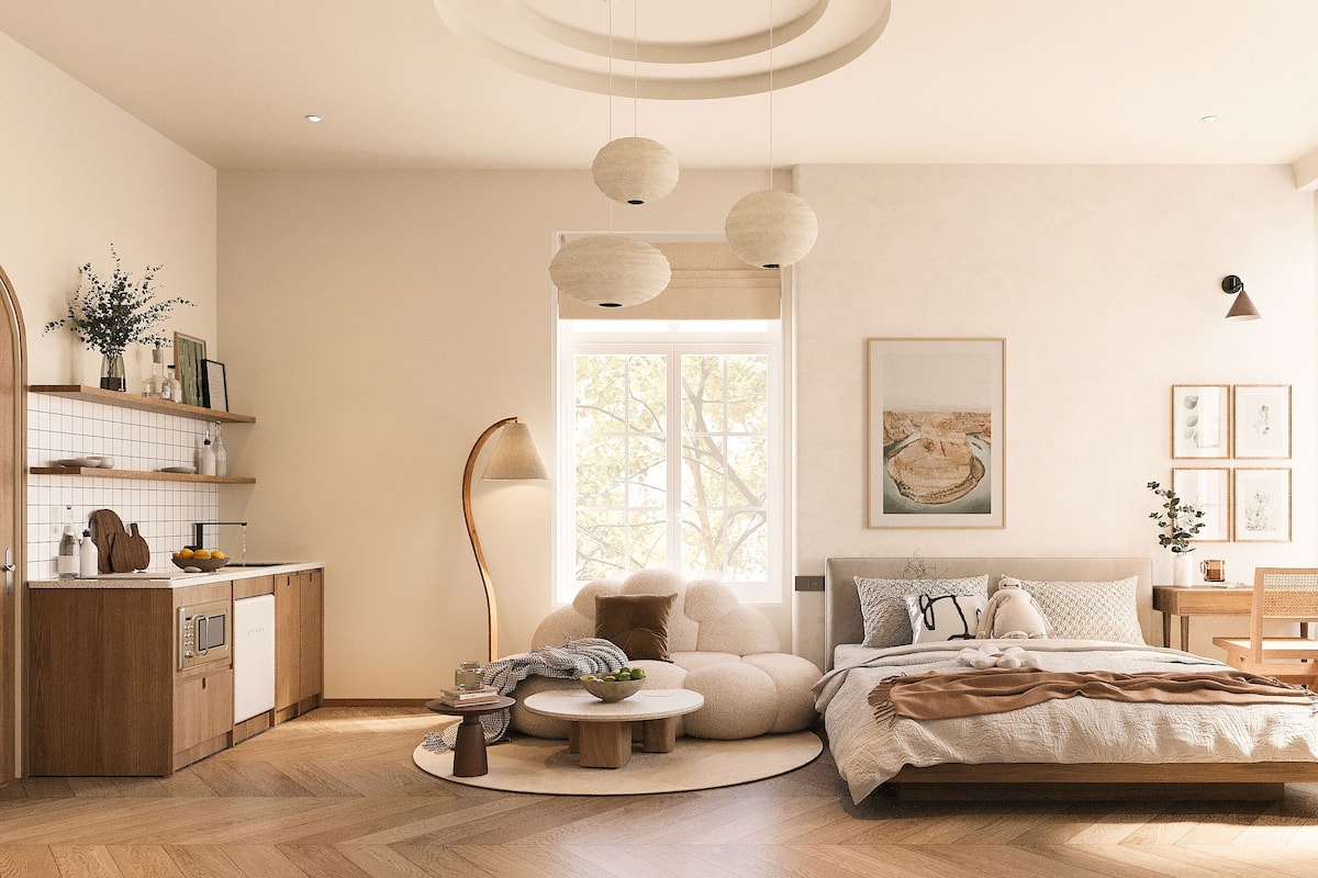 Une chambre à coucher moderne comprenant un lit, des tables de chevet, une table basse ronde, un canapé et un coin repas avec des chaises.