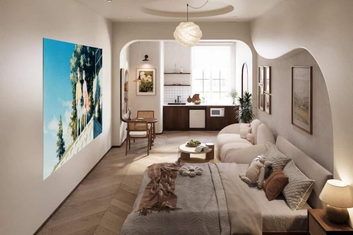 Un intérieur moderne comprenant un canapé, une table à manger, un coin cuisine et un grand tableau accroché au mur.