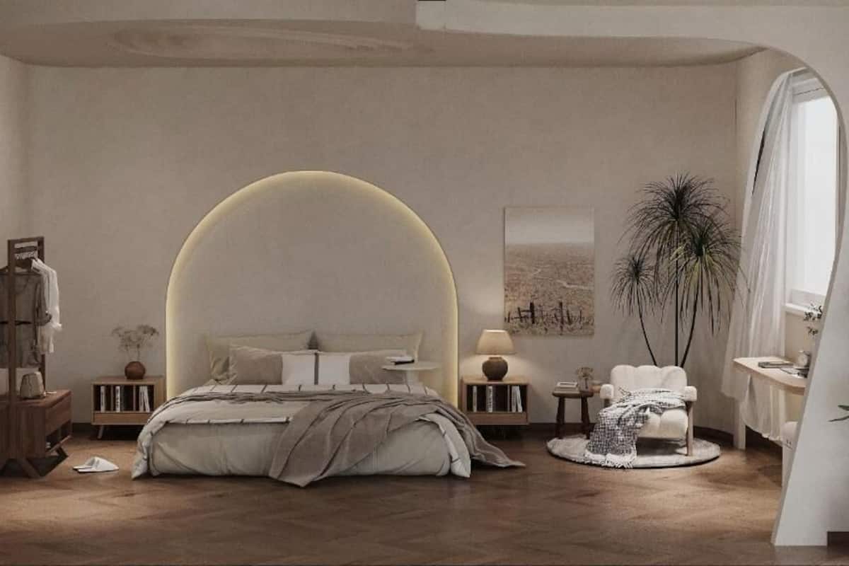 Une chambre à coucher avec un grand lit, des tables de chevet, une chaise, un miroir et une plante.