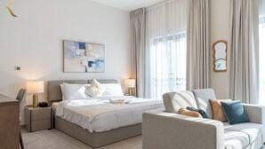 A modern hotel room with a bed, two bedside tables, a sofa, a large window with curtains, and a wall-mounted mirror. - Yas Golf Collection Apartments (Abu Dhabi)