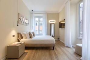 Une chambre à coucher avec un lit, une table de chevet et une fenêtre avec des rideaux.