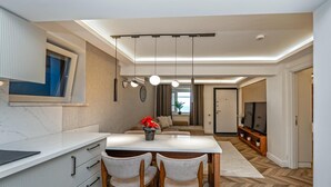 A modern kitchen with a dining area, a sofa, and a TV in a living room. - Modern Sea View Stay Near Istanbul Airport (İstanbul)