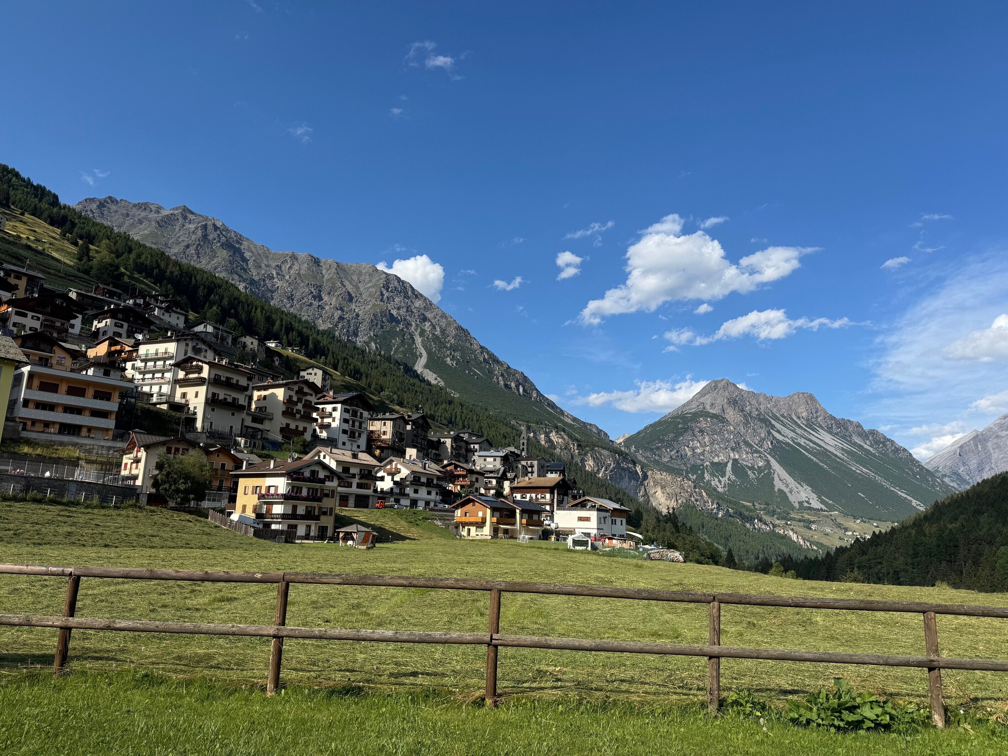Un village de montagne où les bâtiments sont blottis au creux des collines.