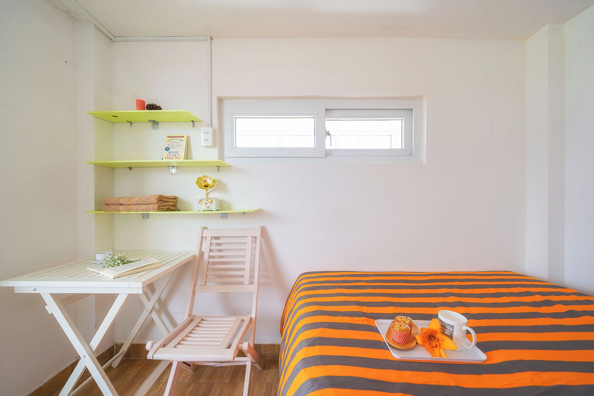 A small room with a bed, a desk, a chair, and a window.