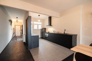 Een moderne keuken met een zwart aanrecht, een spoelbak en een raam.