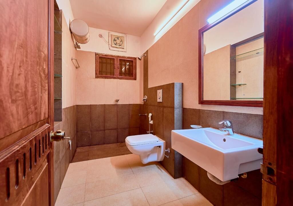 Une salle de bain avec des toilettes, un lavabo et un miroir.