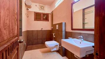 Une salle de bain avec des toilettes, un lavabo et un miroir.
