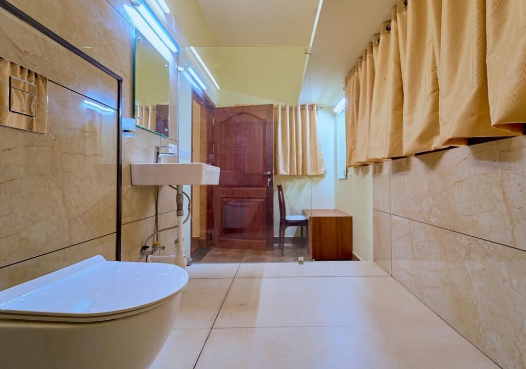 Un baño con bañera, lavamanos, espejo y una puerta que da a otra habitación.