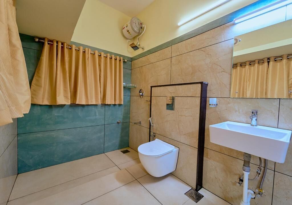 A bathroom with a toilet, sink, and shower area.