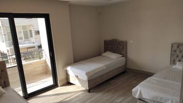 Ein Schlafzimmer mit einem Einzelbett, einem Balkon und Blick ins Freie.