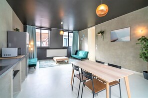 Eine moderne Küche mit Essbereich, einer Couch und einem großen Fenster.