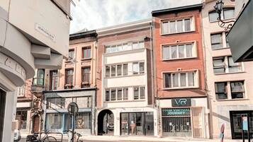 Vista de una calle con edificios, una bicicleta y una tienda con un letrero.