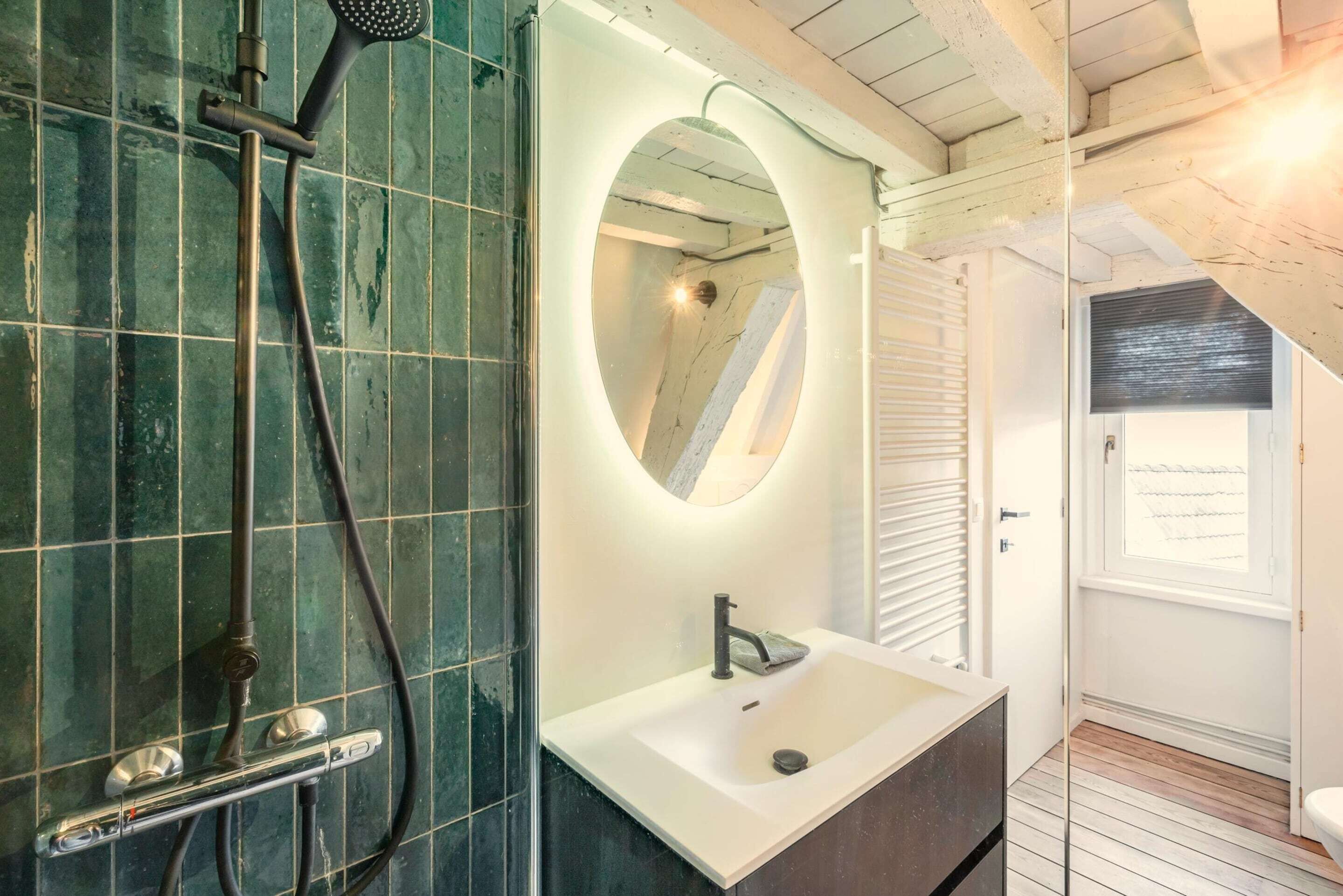Ein Badezimmer mit Dusche, Waschbecken und Spiegel.