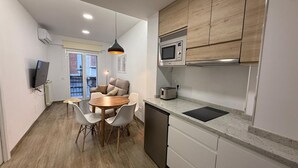 A compact kitchen with a microwave, toaster, and modern cabinetry.