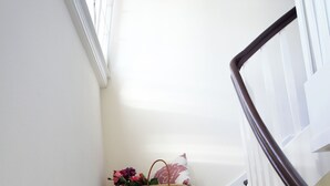 Una escalera con escalones de madera oscura y paredes blancas.