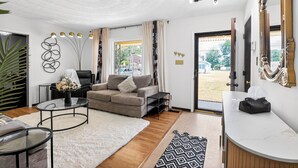 Ein modernes Wohnzimmer mit einer Couch, einem Couchtisch und einem großen Spiegel.