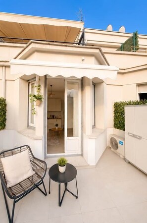 Ein modernes Apartment mit Balkon, einem Essbereich und einer durch eine offene Tür einsehbarer Küche.
