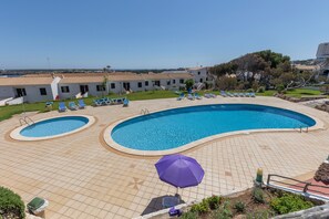 Una piscina divisa in due zone, con lettini e vista sui dintorni.