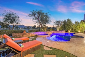 A swimming pool with a stone and brick border, surrounded by a patio with lounge chairs and a view of mountains. - Veranda - On the Greg Norman Course at PGA! (La Quinta)