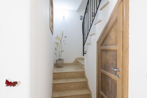 A staircase with a wooden door and a vase with flowers. - Comfortable Praiano Stay with Partial Sea View by Maravista (Praiano)
