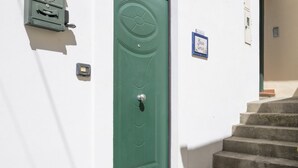 Una puerta verde con una cerradura, un buzón y un cartel en la pared.