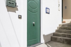 A green door with a keyhole, a mailbox, and a sign on the wall. - Comfortable Praiano Stay with Partial Sea View by Maravista (Praiano)