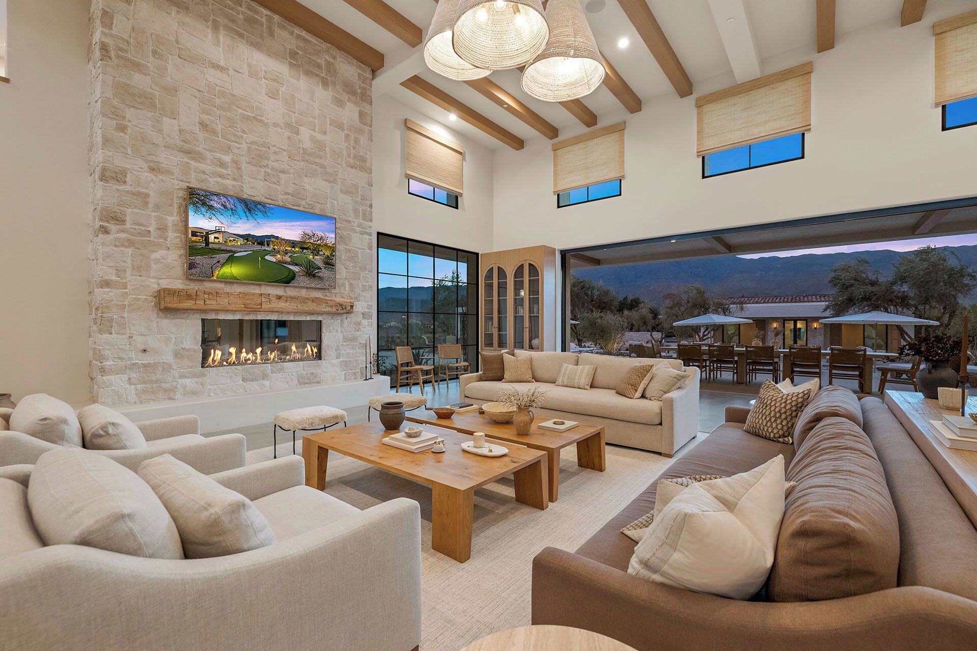 A spacious living area with a stone wall, large windows, and a view of the outdoors.