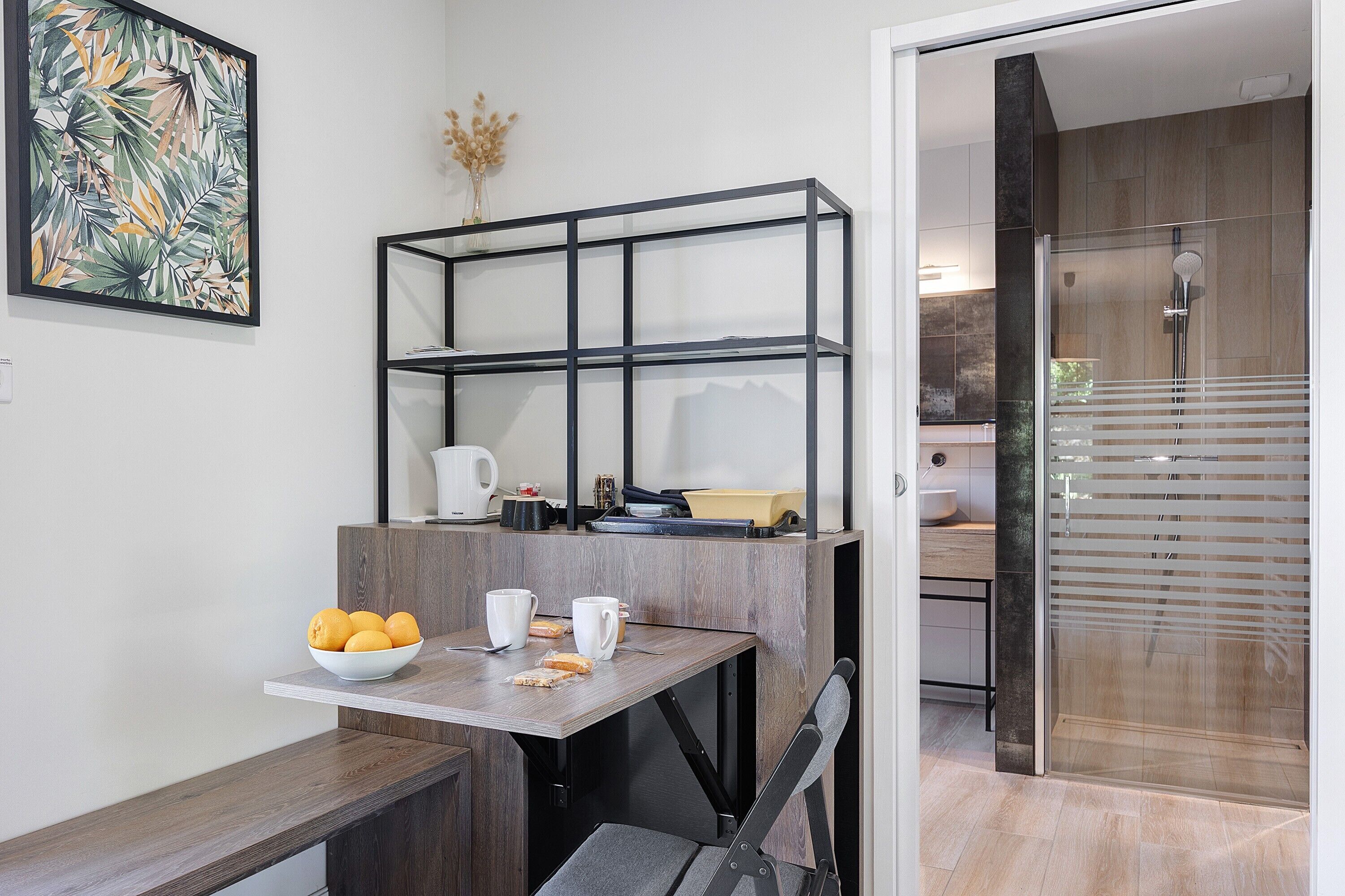 Une salle de bain moderne avec une douche, une porte en verre et un plancher en bois.
