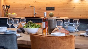 Una cucina moderna con un piano di lavoro in legno, un forno a microonde Bosch e un'area pranzo con sedie e bicchieri da vino.