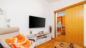 A living room with a sofa, TV, and wooden coffee table. - Apartment with fantastic sea view and balcony in Crikvenica (Crikvenica)