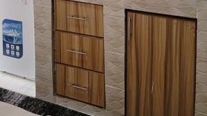 A kitchen with wooden cabinets, a microwave, a toaster, and a sink. - Tranquil studio apartment in welcoming Thika neighborhood. (Thika)
