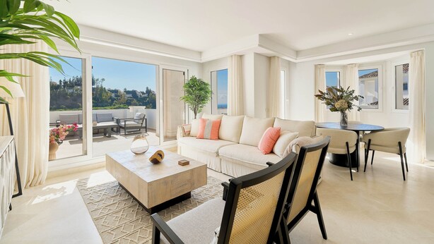A spacious living area with a sofa, coffee table, and chairs, large windows, and a balcony. - Elegant Penthouse Duplex, Sea and Mountain View close to Puerto Banús (Marbella)
