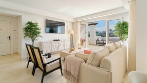 A modern living room with a sofa, dining table, chairs, and a view of the outside. - Elegant Penthouse Duplex, Sea and Mountain View close to Puerto Banús (Marbella)