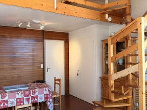 A wooden interior with a dining area, a staircase, and a door. - Central apartment, pets welcome - 6 guests, south balcony (Arâches-la-Frasse)