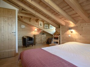 A wooden room with a bed, a chair, a desk, and a staircase. - Chalet in Courchevel 1650, 10 people, parking (Courchevel)