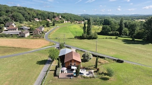 Ein Landhaus mit gepflasterter Auffahrt, Swimmingpool und umzäunter Garten.