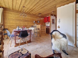 Ein Holzinnenraum mit Essbereich, Küche und einer gemütlichen Sitzecke.