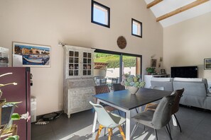 A dining area with a table, chairs, and a view of the outdoors.