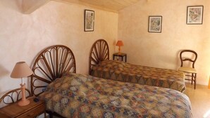 A bedroom with two wooden beds, a nightstand, a chair, and a lamp. - Peaceful villa with pool, pets welcome - 8 guests (Vielle-Saint-Girons)
