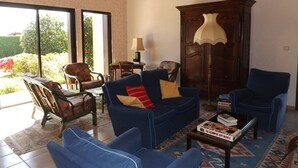 A living room with a sofa, chairs, a cabinet, and a table with books. - Peaceful villa with pool, pets welcome - 8 guests (Vielle-Saint-Girons)