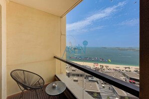 Ein Balkon mit Blick auf einen Strand, ein Riesenrad und einen klaren Himmel.