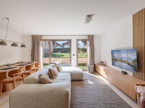 Ein modernes Zimmer mit einer Couch, einem Schreibtisch und einem Fernseher.