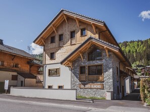 Ein mehrstöckiges Gebäude mit einer Steinfassade und oberen Stockwerken aus Holz, genannt 'LES DENTS BLANCHES'.