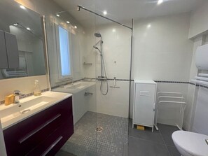 A modern bathroom with a glass-enclosed shower, a vanity with a mirror, and a toilet. - Modern villa with pool and parking - La Grande Motte (La Grande-Motte)