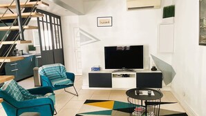 A modern living room with a sofa, a chair, a coffee table, a TV, and a staircase. - Modern villa with pool and parking - La Grande Motte (La Grande-Motte)