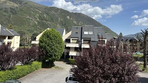 Un quartier résidentiel avec des immeubles modernes, une allée pavée et une chaîne de montagnes en arrière-plan.